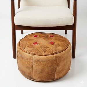 Moroccan-style round leather painted ottoman that is handcrafted